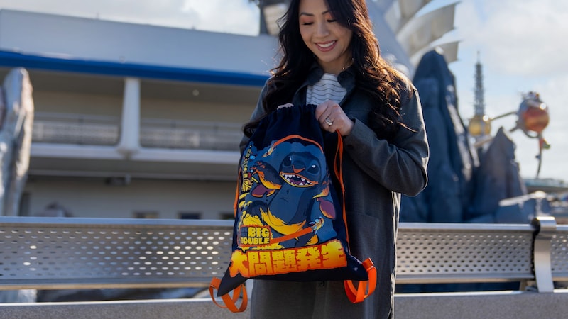 A Guest holding a backpack featuring Stitch