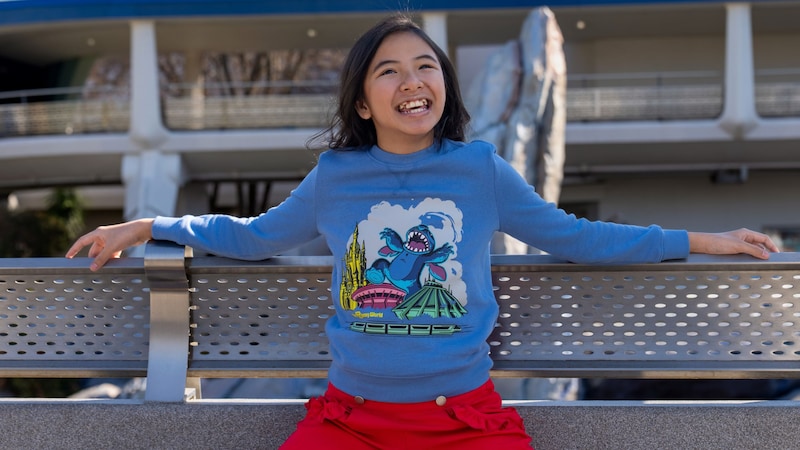 A Guest wearing a sweatshirt featuring Stitch