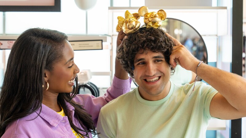 Two Guests shopping for Mickey Mouse ear headbands inside of a Disney gift store