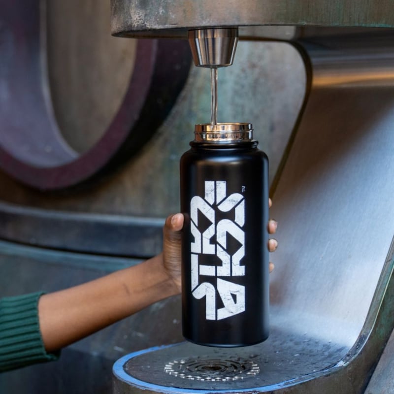 A Guest filling up a Star Wars themed water bottle at Disney's Hollywood Studios theme park