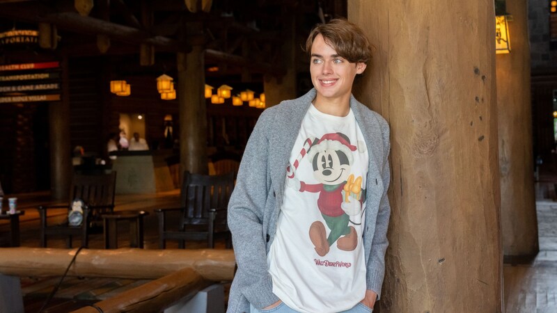 A teenage boy wearing a holiday Mickey Mouse shirt from the Disney Holiday Collection