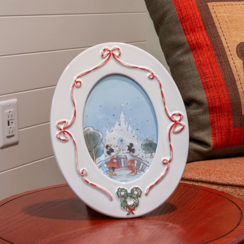 A picture frame decorated with ribbons featuring Mickey Mouse and Minnie Mouse