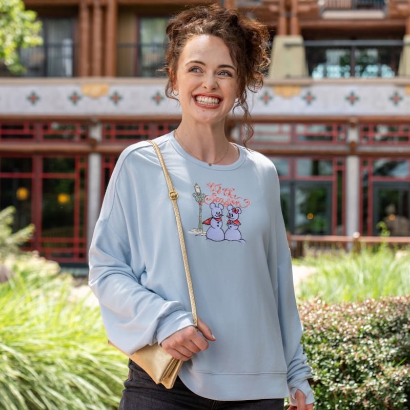A woman wearing a sweatshirt from the Disney Holiday Collection
