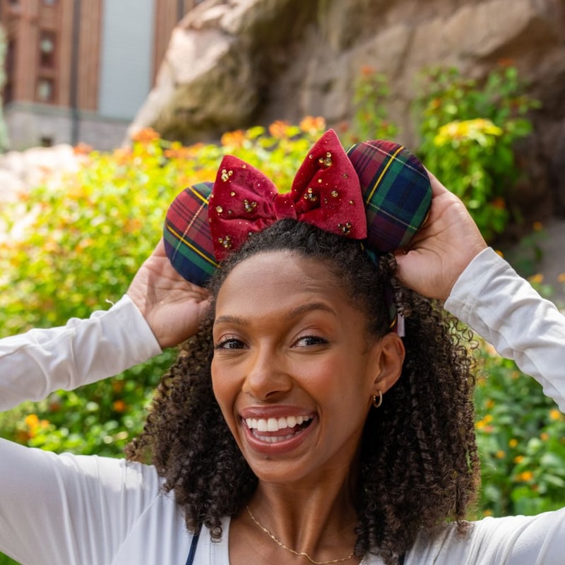 A woman wearing a holiday themed Minnie Mouse ear headband