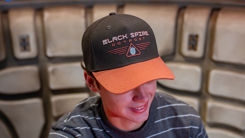A man wearing a hat with the words ‘Black Spire Outpost’