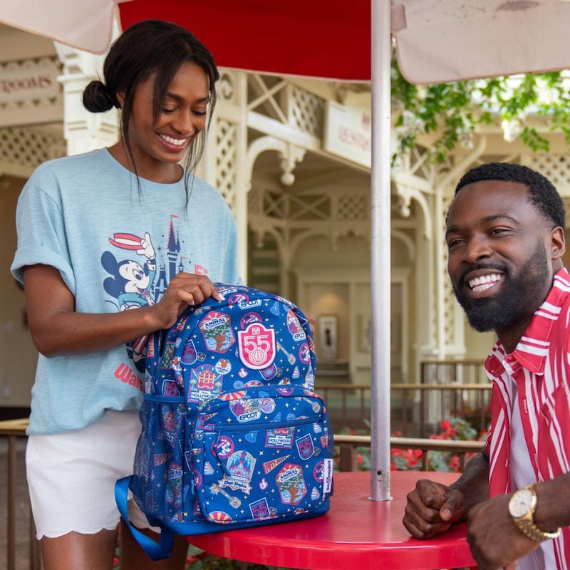 Two Guests at an outdoor table with a Walt Disney World themed backpack