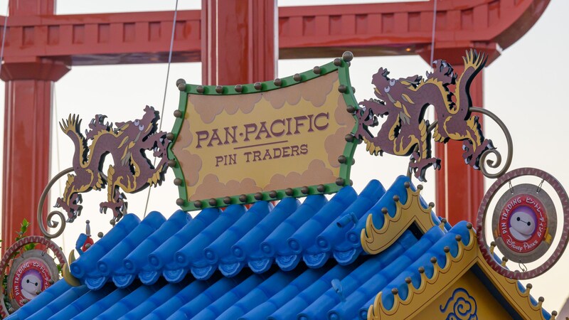 Artistic outdoor signage with 2 dragons that says Pan Pacific Pin Traders, located in San Fransokyo Square at Disney California Adventure Park