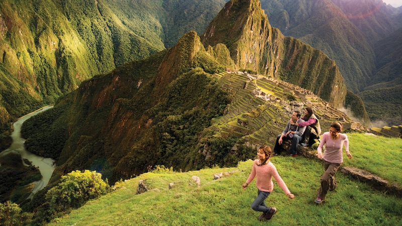 A family views Machu Picchu from a nearby mountaintop in Peru