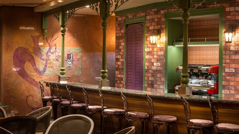 A French Quarter inspired bar with early 20th century decorative accents, including French stools, a faux brick wall and a mural depicting a potion maker 