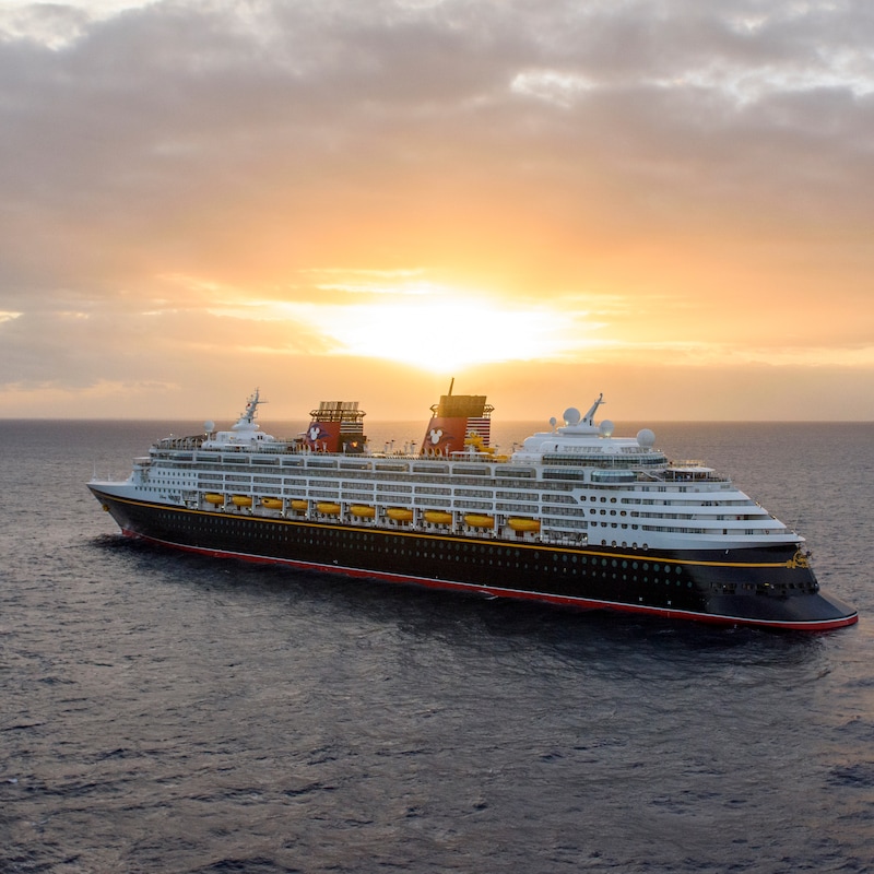 A Disney cruise ship sails the open seas at sunset