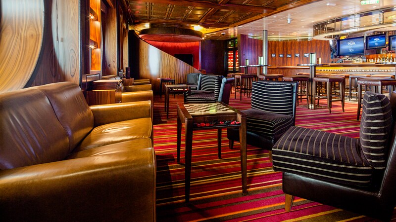 A lounge with a row of sofas opposite easy chairs with a cocktail table