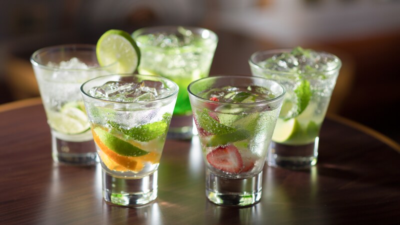 5 glasses containing various types of mojito and caipirinha
