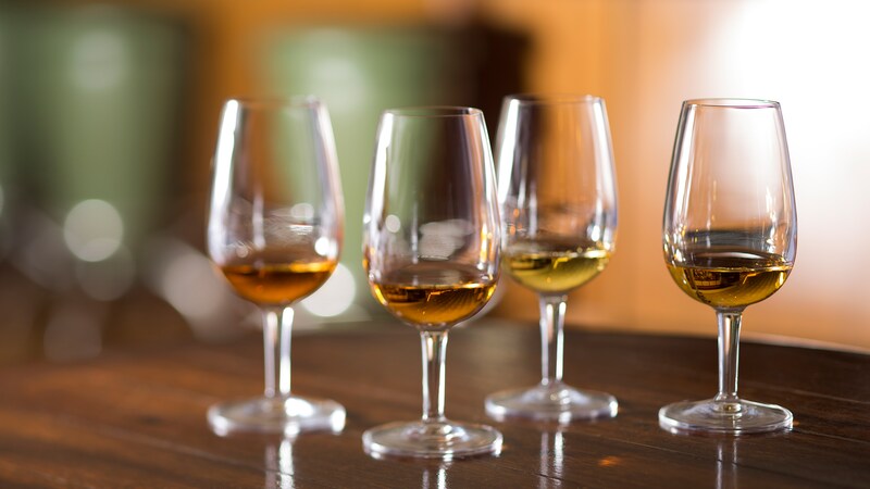 4 glasses containing various types of whiskey