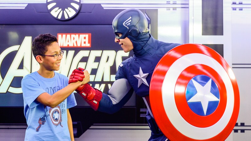 A boy shakes hands with Captain America, of The Avengers