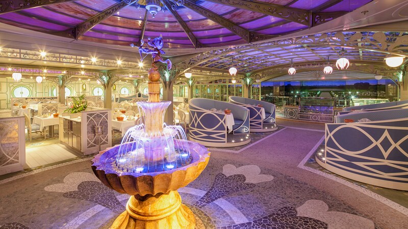 The Enchanted Garden restaurant with elegant booths, hanging flower lights and a fountain with a cherub Mickey
