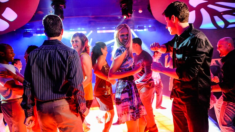 Men and women fill the dance floor and enjoy the music