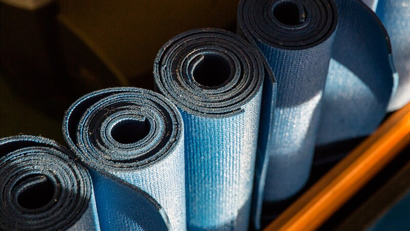Top view of 4 rolled up workout mats lined up and ready for use