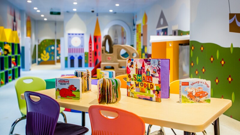 A table and chairs with childrens books, at Its a Small World Nursery on the Disney Dream