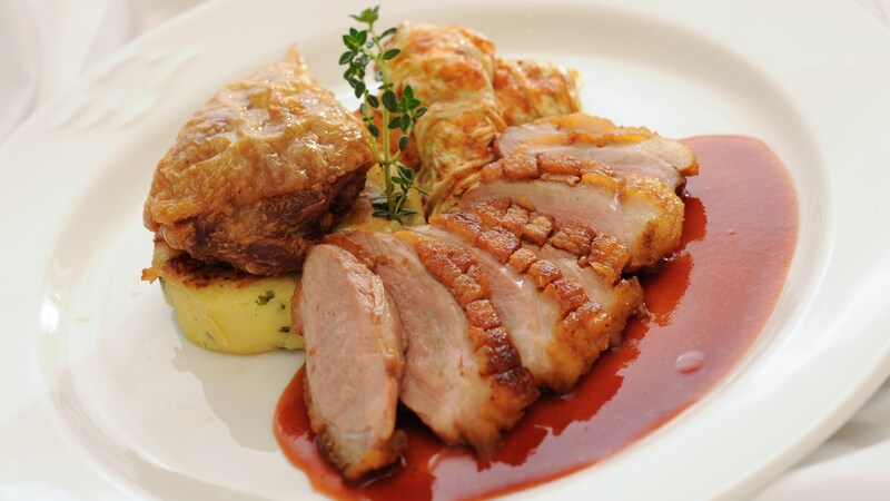 Crispy roasted duck breast with braised Napa cabbage and potato cake, with pomegranate sauce