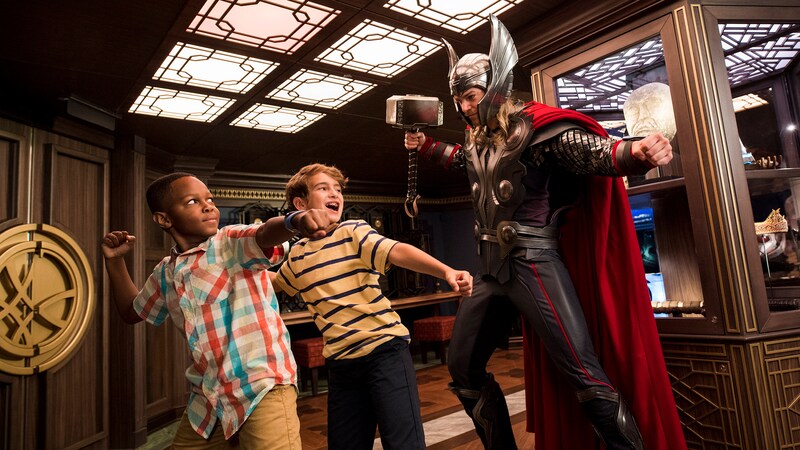2 boys pose next to Thor