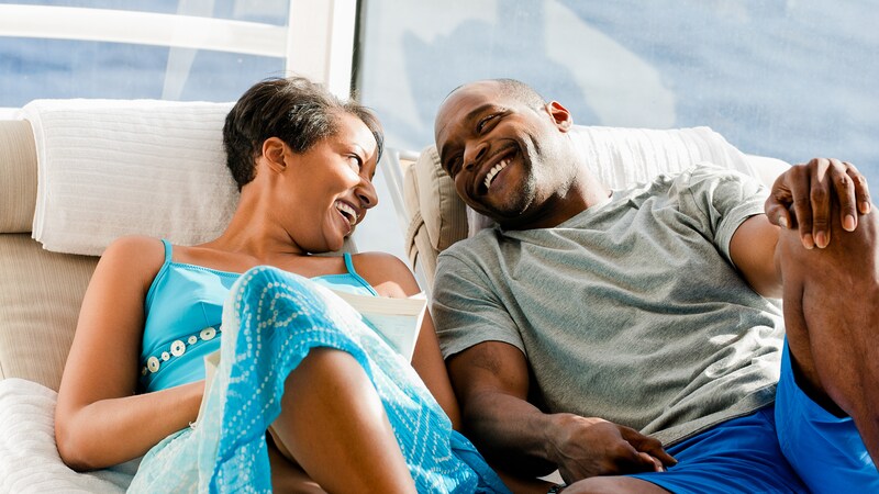 A couple relaxing on lounge chairs and enjoying a laugh together
