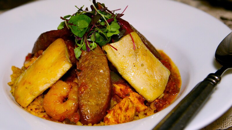 A carefully presented jambalaya dish with elements of chicken, shrimp and sausage