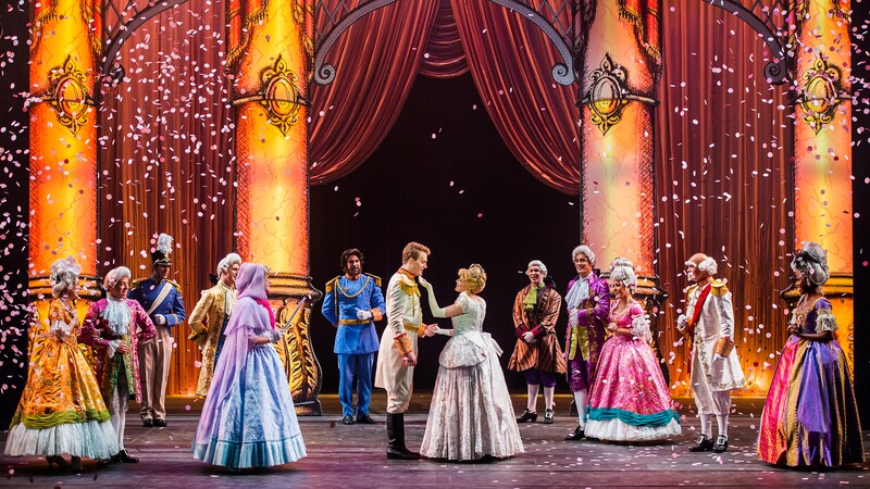 Cinderella meets her prince at the royal ball, with her Fairy Godmother nearby