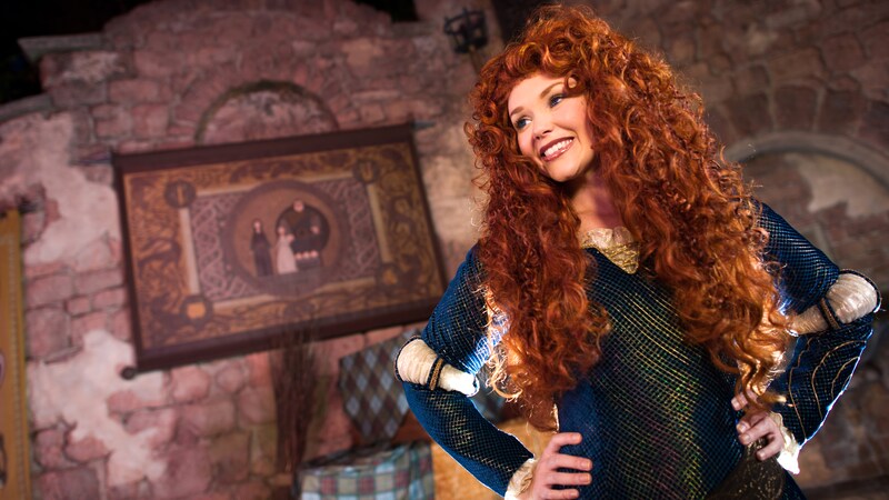 A woman with long curly locks in a princess costume