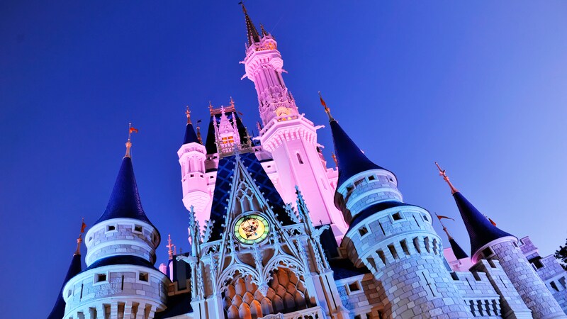 Cinderella Castle with its top spires bathed in pink light at night