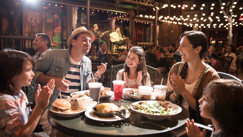 A family of 5 clink glasses over a celebratory lunch at Disney Springs