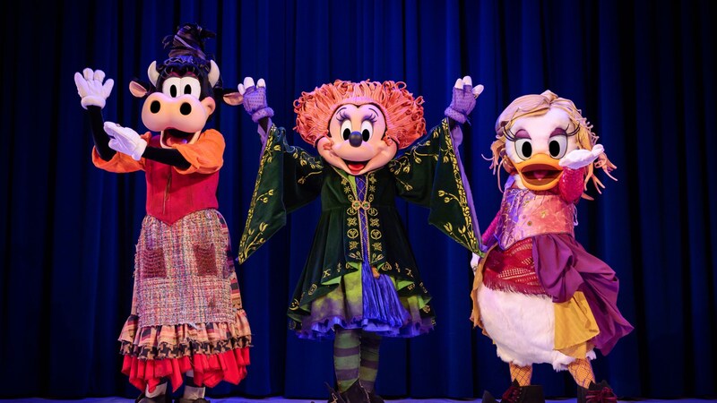 Clarabelle Cow, Minnie Mouse and Daisy Duck dressed as the Sanderson Sisters from Hocus Pocus on stage