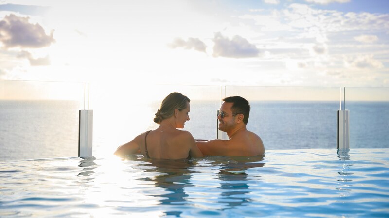 Two Guests relaxing and enjoying the view from an infinity pool on a Disney Cruise Line ship