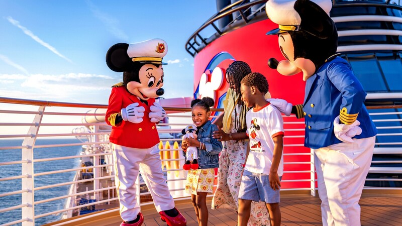 A family of 3 meeting Captain Mickey Mouse and Captain Minnie Mouse on a Disney Cruise Line ship