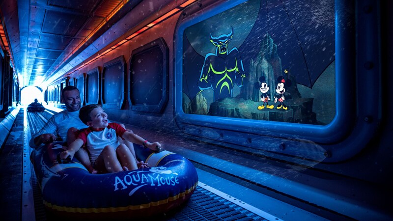 A boy and his father on the Aqua Mouse ride and an image of Mickey and Minnie Mouse and Chernabog