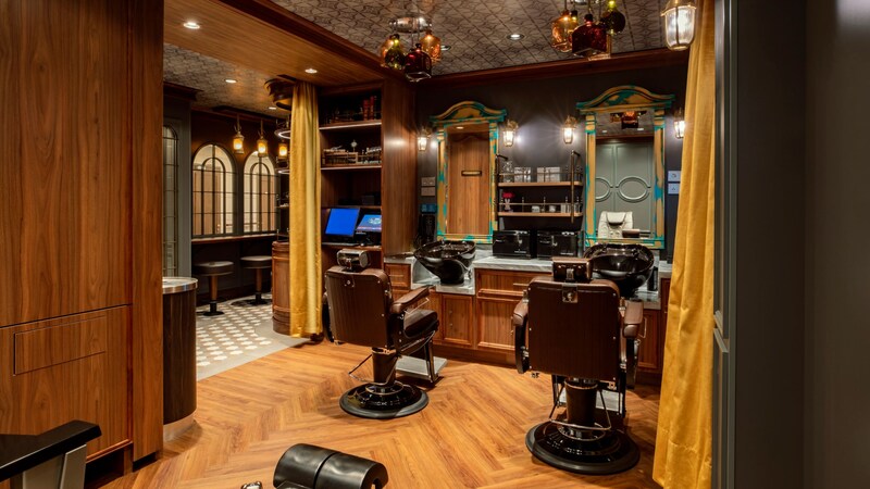 Two barber chairs inside Hook’s Barbery on board the Disney Destiny ship