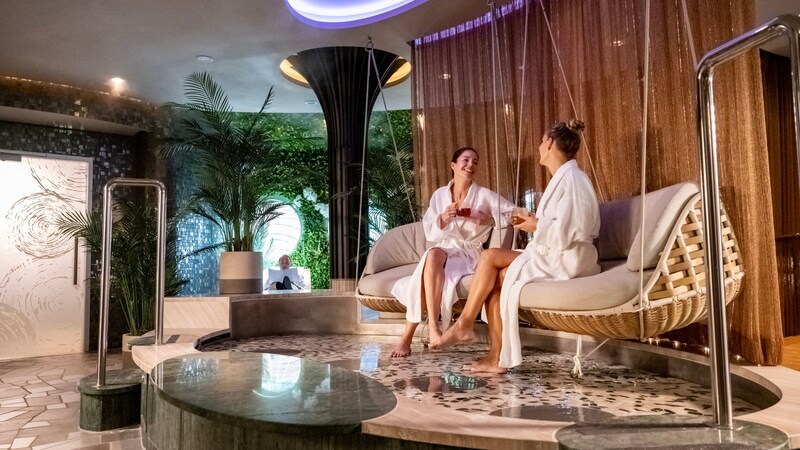 Two women in robes sitting on couches at Senses Spa on board the Disney Destiny ship
