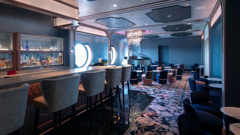 The interior of Nightingale’s reveals an elegant piano lounge with a bar, cushioned seating and port hole windows