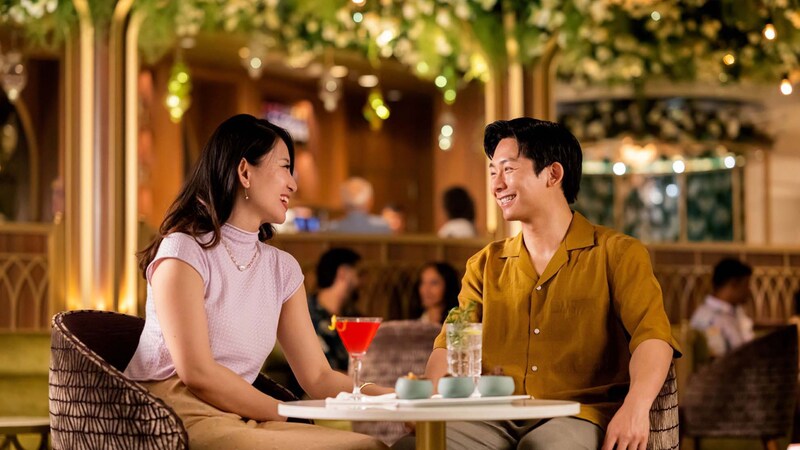 A couple smiles while dining at Tiana’s Bayou Lounge on board the Disney Adventure
