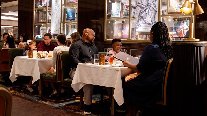 Diverse groups of families dining at a venue aboard a Disney cruise ship 