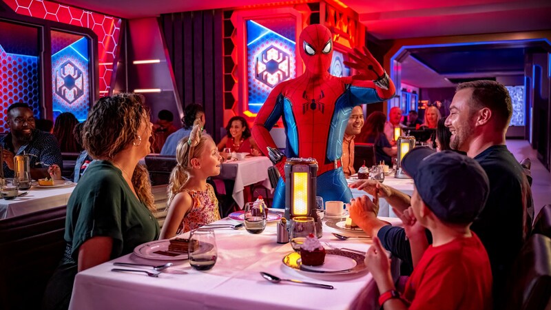 Spider-Man interacting with a family of 4 inside the Worlds of Marvel restaurant  