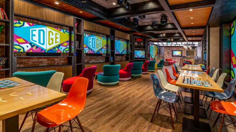 A youth club with books, movies, TV screens, tables with board games, overstuffed chairs and more