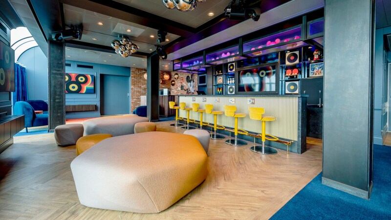 The Hideaway youth club with TVs, sofas, large poufs and a bar with bar seats