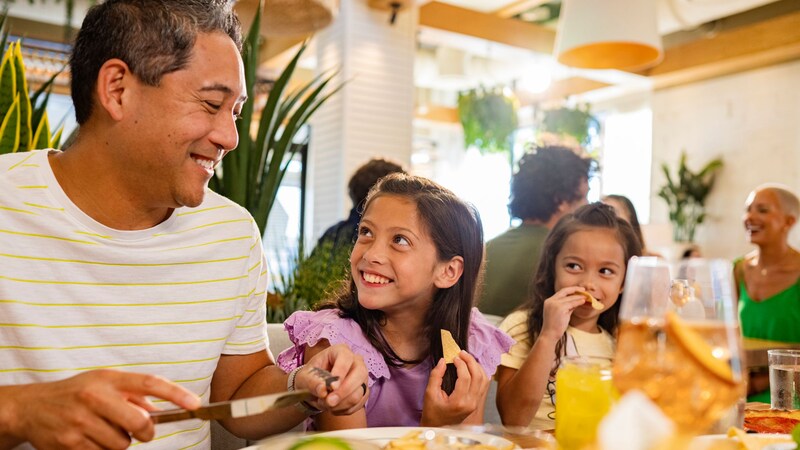 A man enjoying a meal with his 2 daughters at Summer House on the Lake