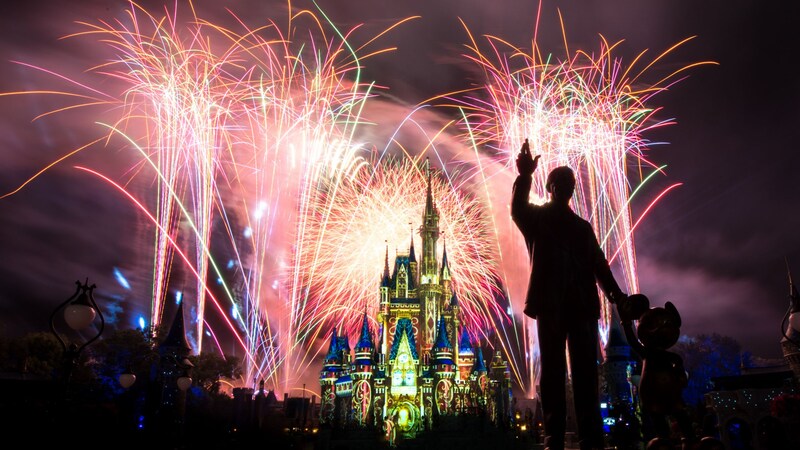 Fireworks burst in the sky over Cinderella Castle and the Partners statue of Walt Disney with Mickey Mouse at Magic Kingdom park
