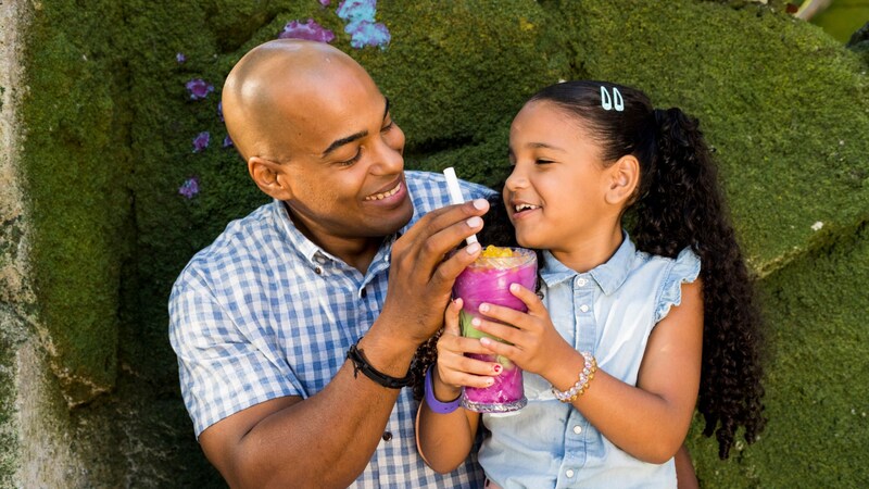 An adult and child sharing a colorful drink at Pongu Pongu in Disney's Animal Kingdom park