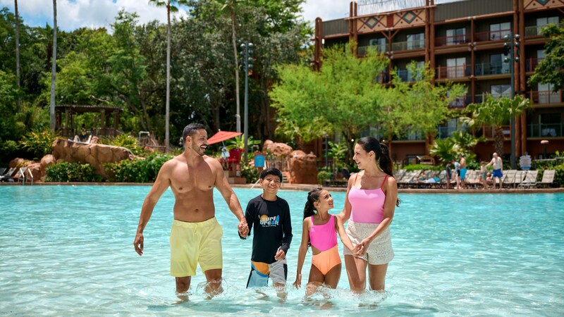 A family of 4 standing in the shallow end of the pool at Disney's Animal Kingdom Lodge
