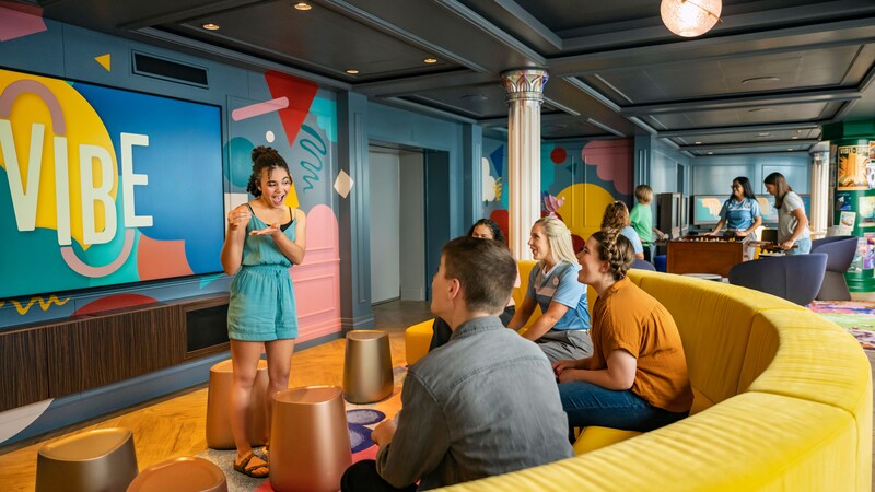 A group of teens hanging out at Vibe, a teens exclusive space aboard a Disney cruise ship