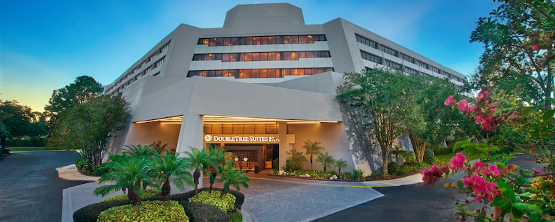 The entrance of a hotel building with a sign saying ‘Double Tree Suites’