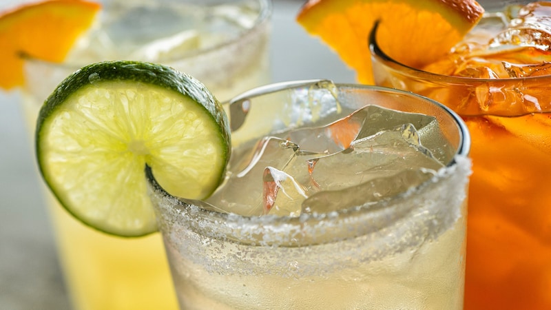 Iced glass of margarita on the rocks with a wedge of lime and other specialty drinks from Dockside Margaritas