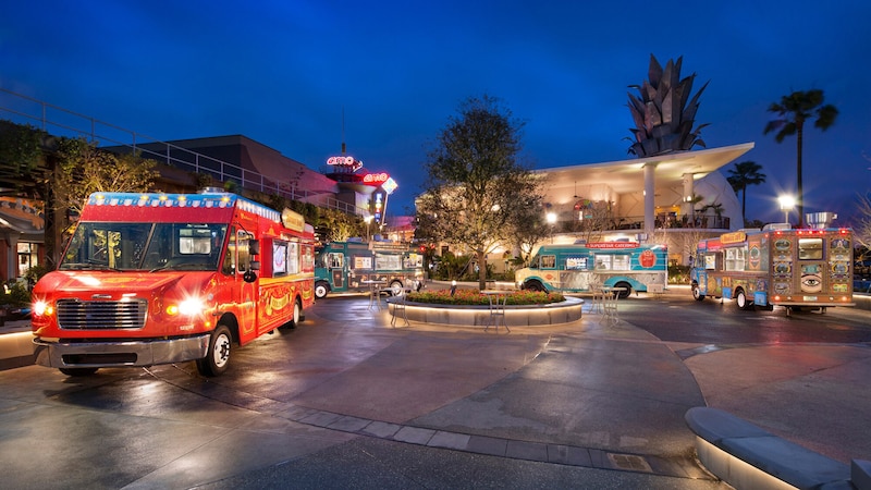 Food trucks parked beneath the vibrant evening lights of Disney Springs at Walt Disney World Resort